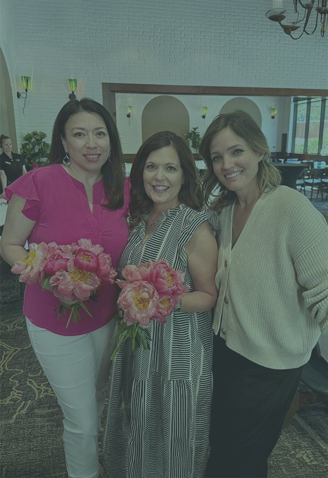 Three women posing for the camera and smiling