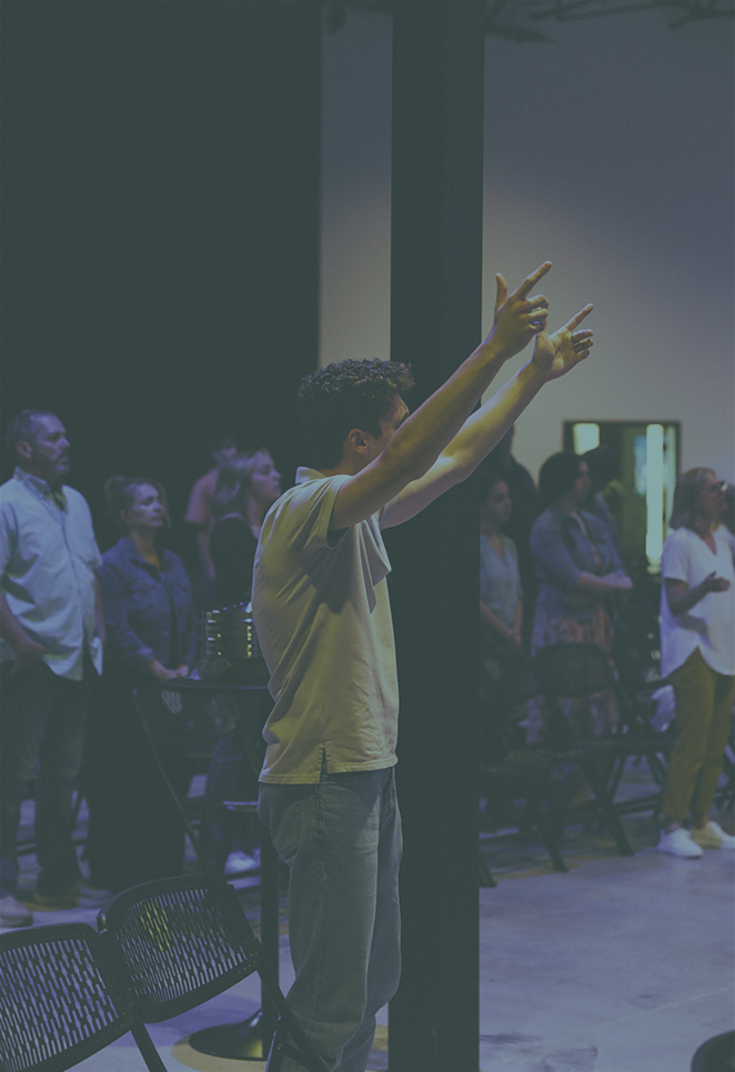 Young man with his arms raising worshiping Jesus